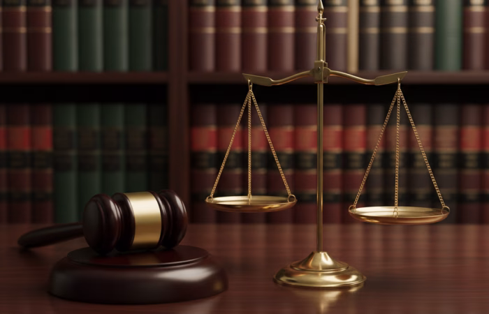 Professional legal concept featuring a gold balance scale and wooden gavel on a desk, representing commercial litigation and settlement cost-shifting strategies such as Calderbank Offer.