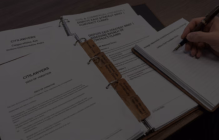 A professional top-down, close-up landscape header image featuring a subtle dark color overlay for website hero text compatibility. The desk workspace displays organized legal files and binders from Citilawyers, including a "Dispute Case Strategy Brief | Assessing Breach of Contract Claims" document with specialized leather index tabs labeled "Relevant Terms," "Breach of Supply / Business Sale / Warranty Claims," "Restraint / Confidentiality," and "Debt Recovery / Non-Payment." On the right, a commercial litigator's hand in a professional suit holds a classic fountain pen, drafting notes on a notepad with the heading "Uniform Civil Procedure Rules" next to an open "Deed of Variation" document.